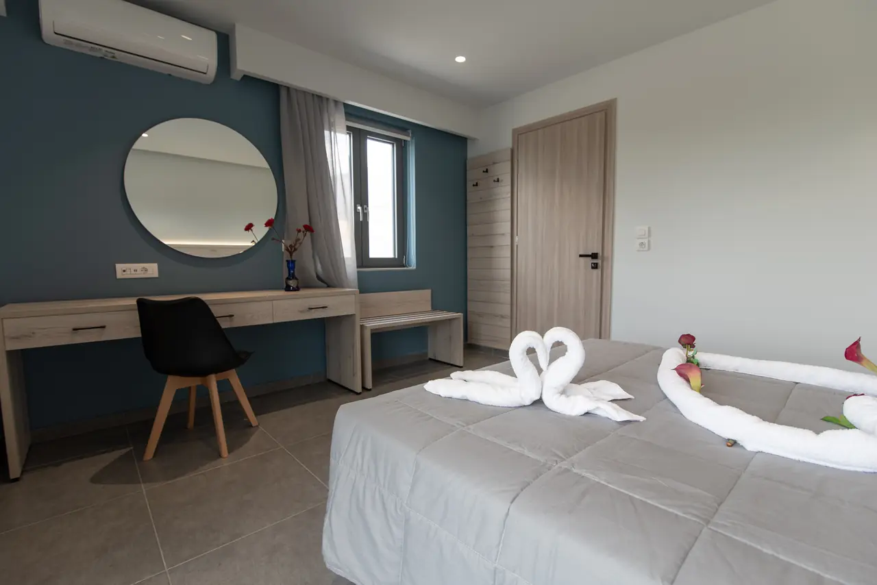 Bedroom with desk and towel art on the bed