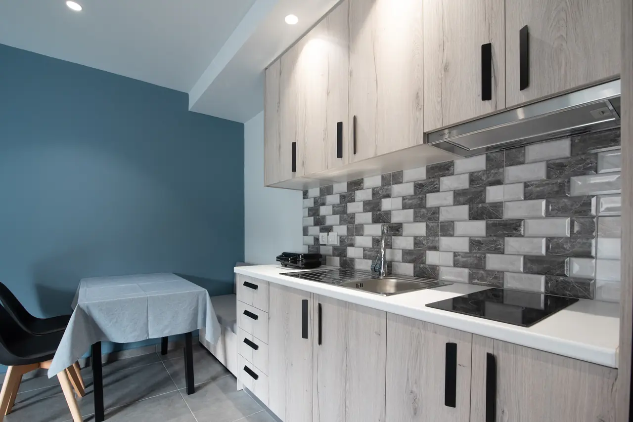 Kitchen with hob, cabinets and dining table