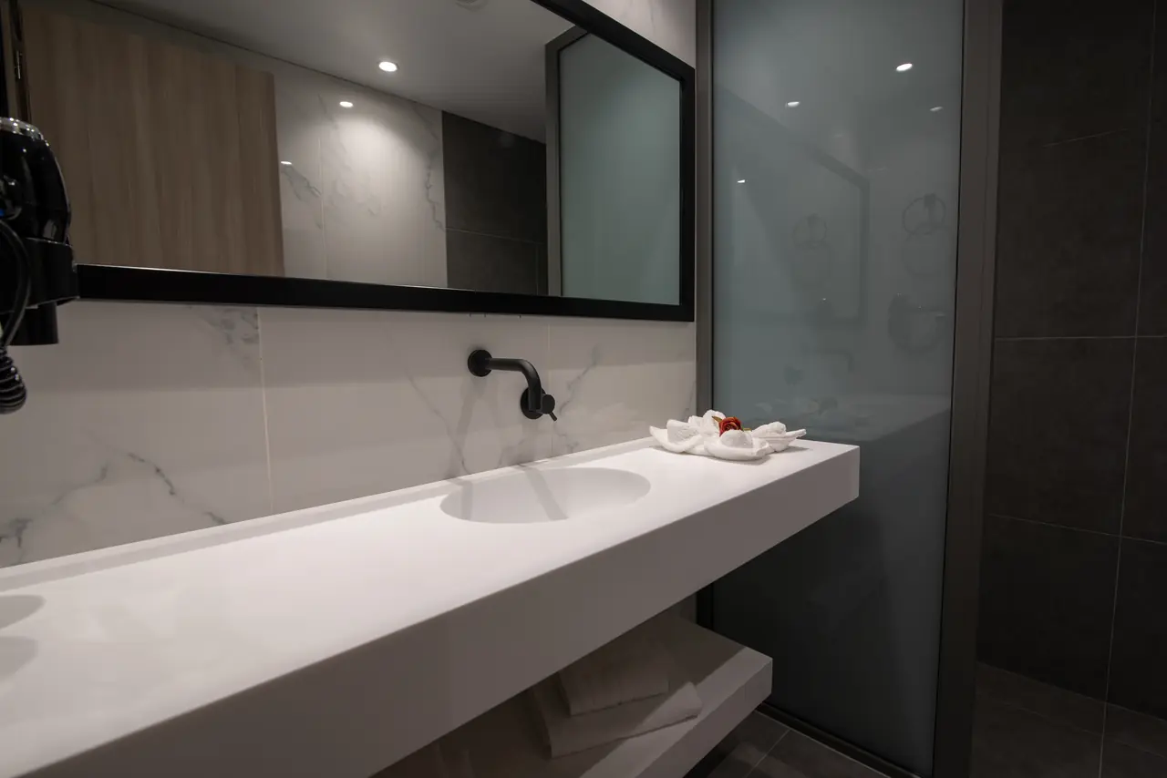 Marble bathroom with a long vanity and a glass shower