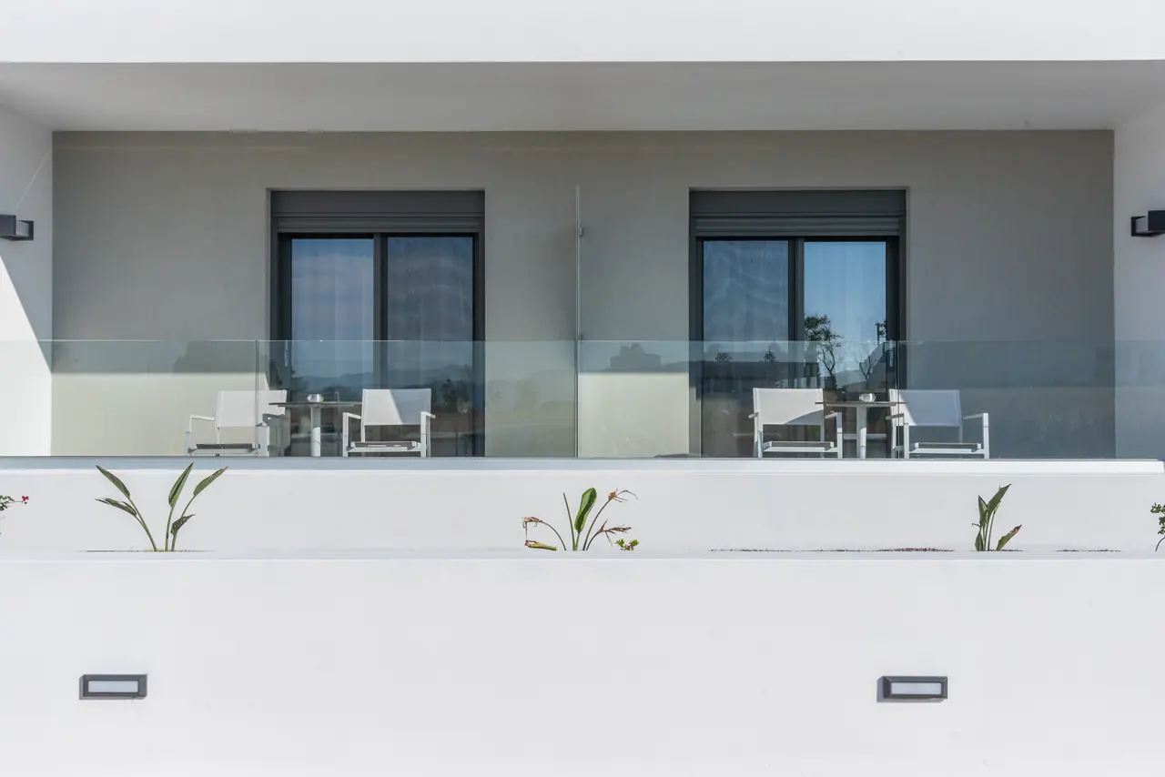 Two verandas with glass railings and sun loungers