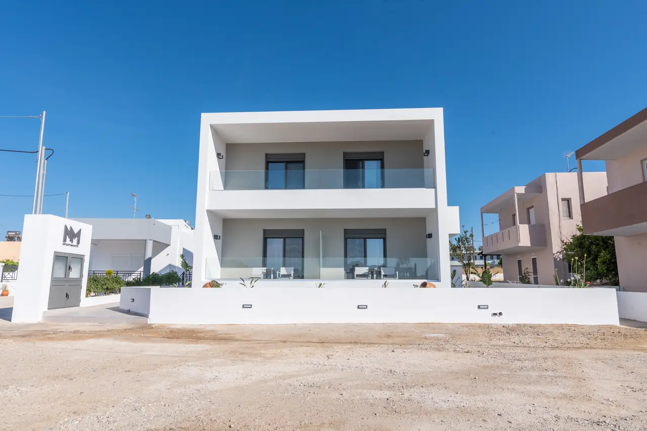 Front of the white NM Apartments building with glass balconies