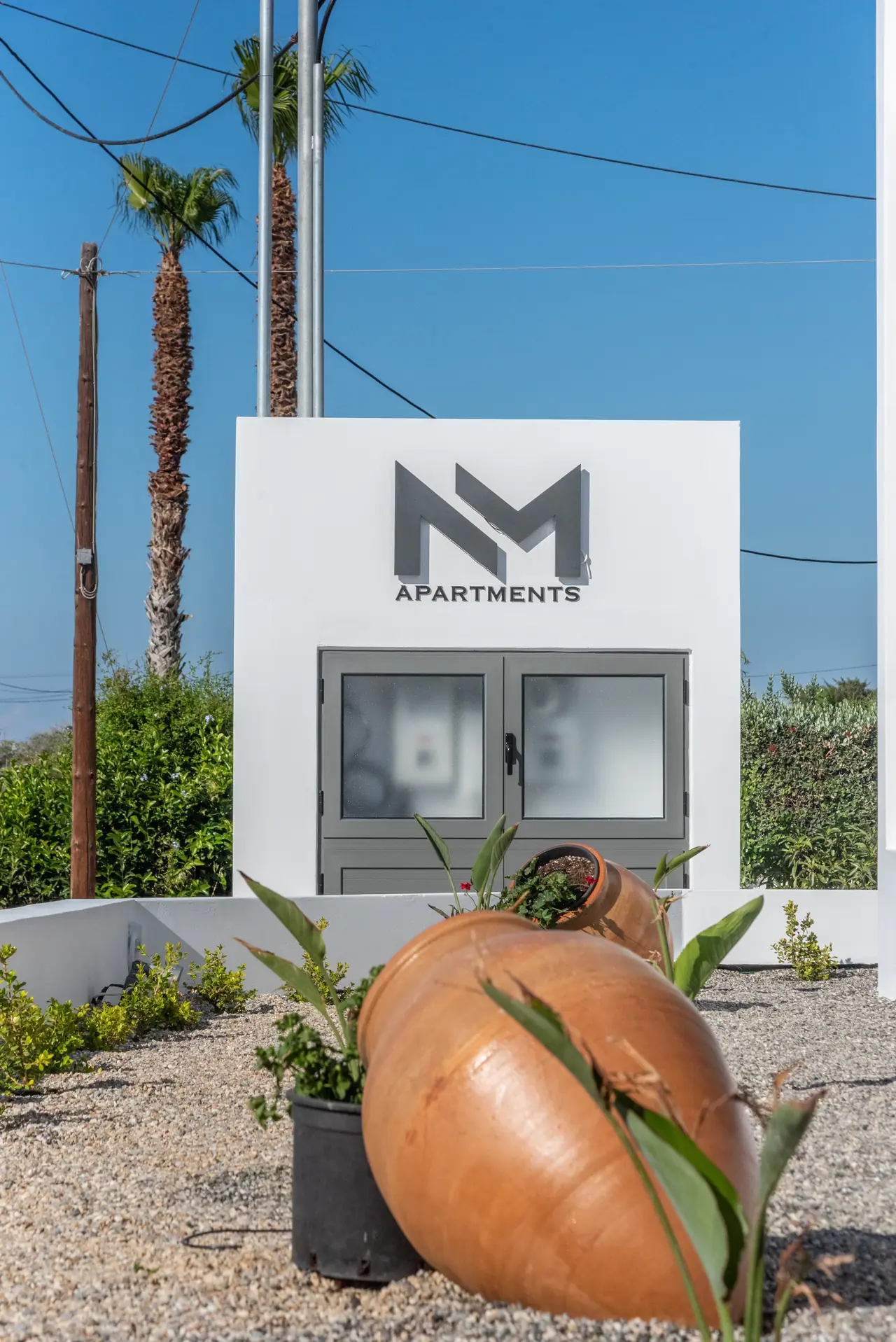 Entrance of NM Apartments with the NM sign and a palm tree