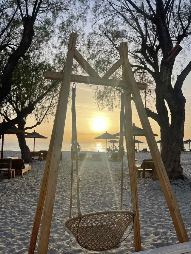 A swing on the beach at sunset